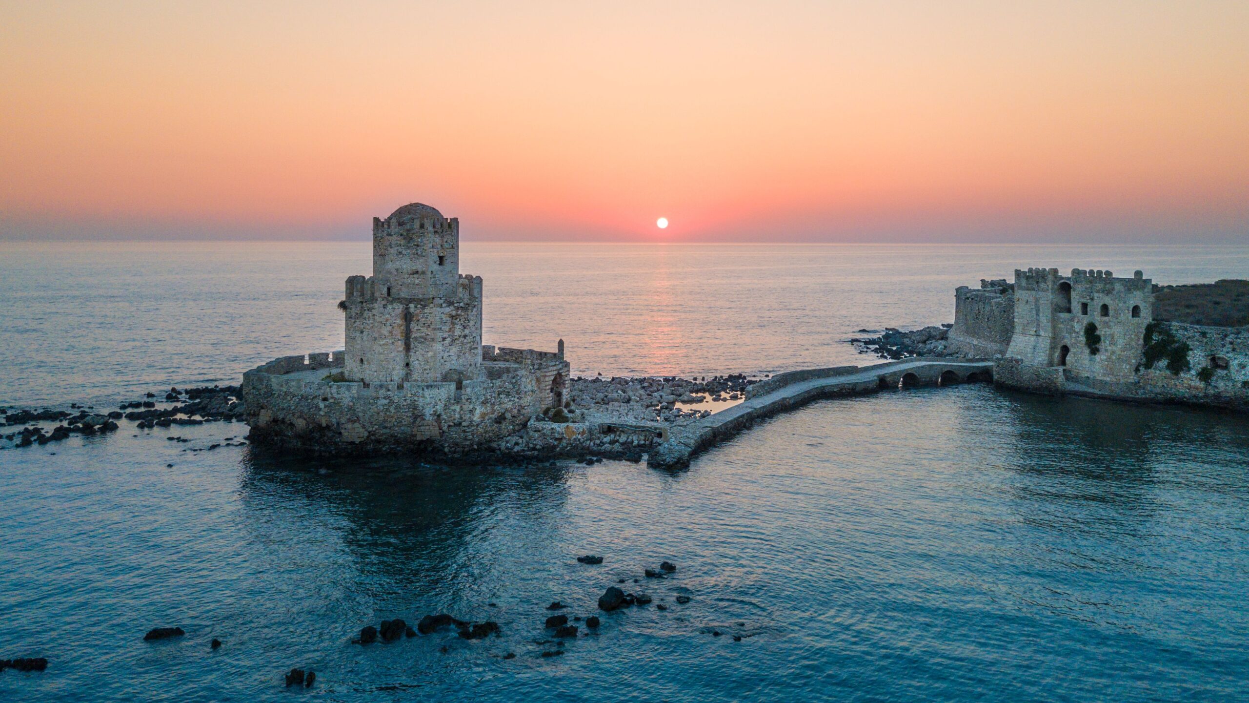 Pemandangan udara yang menakjubkan dari Kastil Methoni saat matahari terbenam di atas laut yang tenang di Yunani.